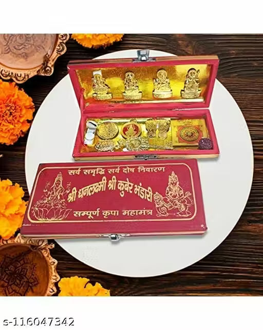Set of gold-colored religious items in a decorative box on a wooden surface with marigold flowers.